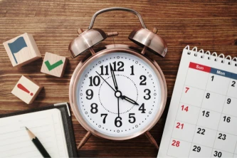 Reloj despertador y calendario con bloques de tareas, gestión del tiempo en reformas.