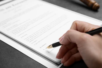 Firma de un contrato legal con un bolígrafo, representando acuerdos de reforma.