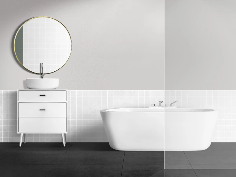 Baño minimalista en blanco con bañera independiente y espejo redondo.