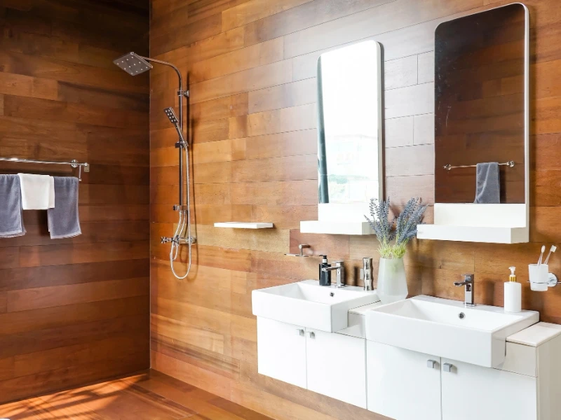 Baño contemporáneo con revestimiento de madera y lavabos modernos.