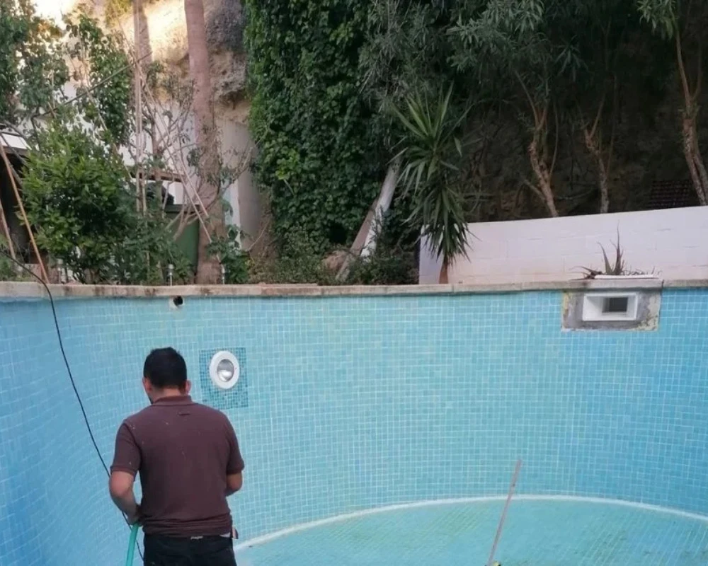 Trabajador realizando mantenimiento en piscina vacía en Menorca