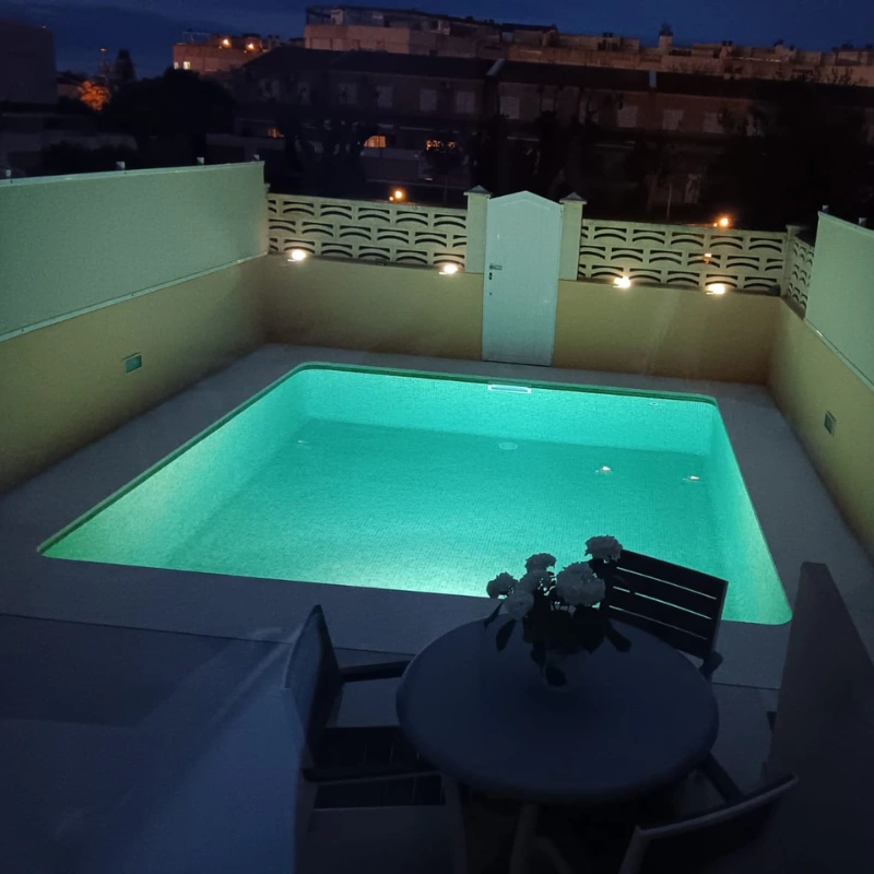 Piscina iluminada en chalet de Menorca tras reforma completa.